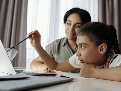 Beispielbild einfache Sprache für Menschen mit Migrationshintergrund: Eine junge Frau und ihre Tochter mit Migrationshintergrund beim Lernen am Computer